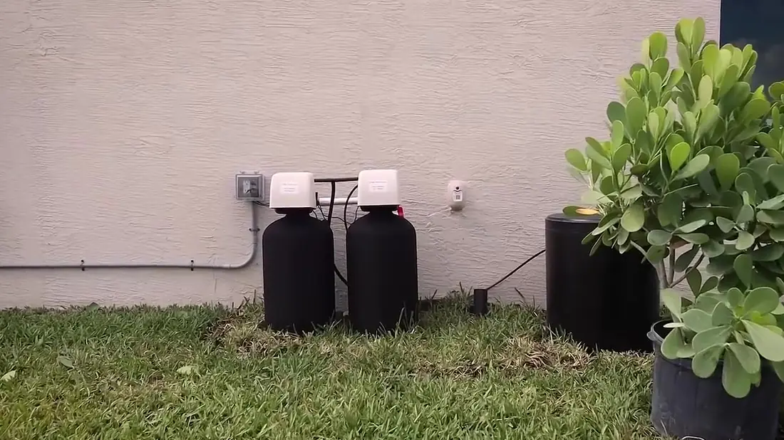 Dual-tank whole-home carbon filter and water softener installed by Simple Water Service outside a Palm Beach County home